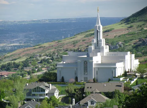 The Bountiful Utah Temple on the hillside above Bountiful homes, with the valley behind