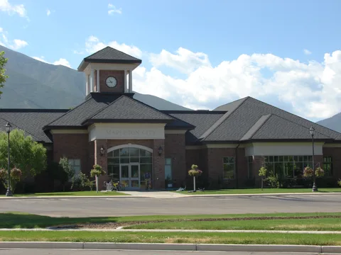 Mapleton's city building, with its clock tower and the mountains behind it