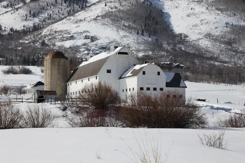 The white McPolin Farm barn in deep snow below the Park City hills