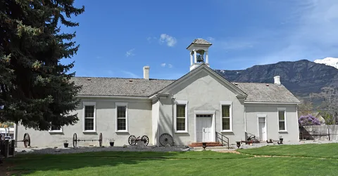 Pleasant Grove's historic Old Bell School, now a pioneer museum, with the Wasatch Mountains behind