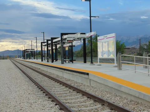 The Vineyard FrontRunner station platform under an evening sky, with the Wasatch Mountains behind