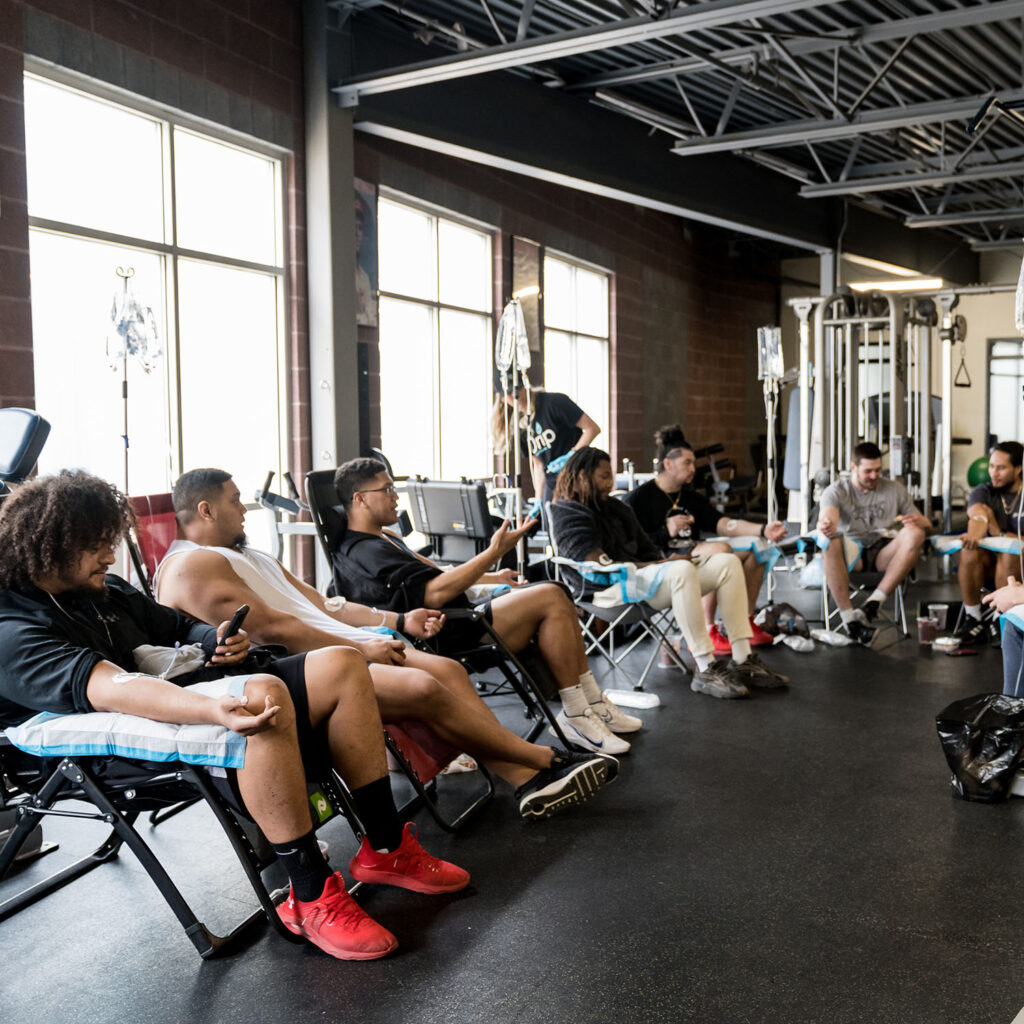 Gym members receiving recovery IV Therapy in a gym