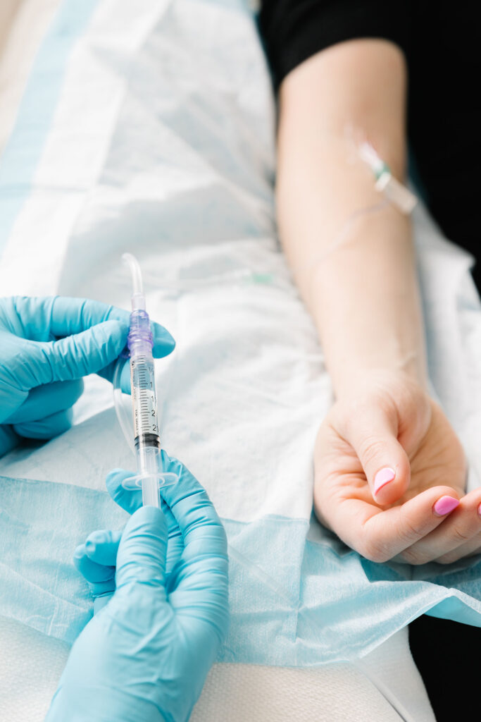 Close up of nurse prepping a vitamin for the IV that is already in a patient's arm
