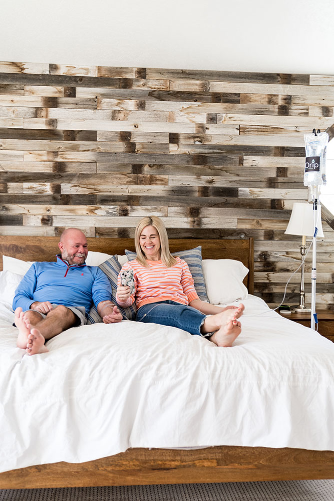 A Couple sitting on the bed getting relaxing IV therapy in draper