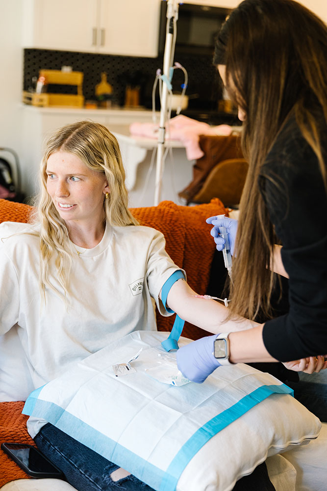 Mobile IV Therapy in Riverton UT being received by a young woman on a couch with a pillow on her lap