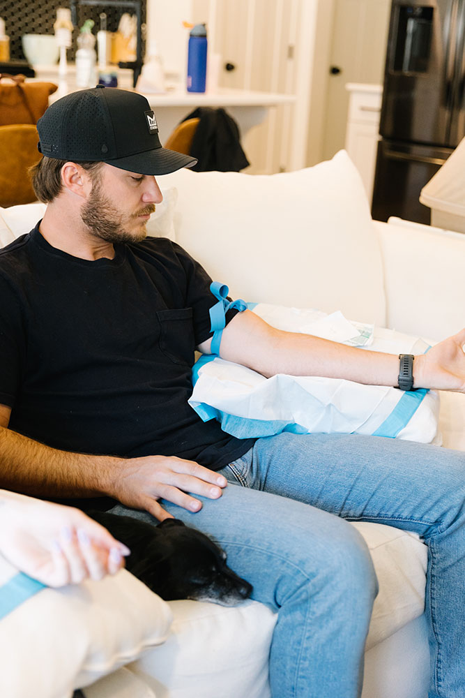 Oxygen IV Therapy being administered to a man on a white couch with his arm outstretched, ready for the treatment