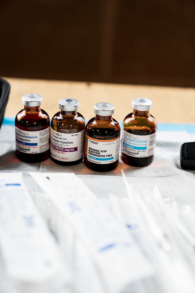 Line up of the best energy supplements for chronic fatigue vitamin bar vials on a table with syringes in packaging in front of them