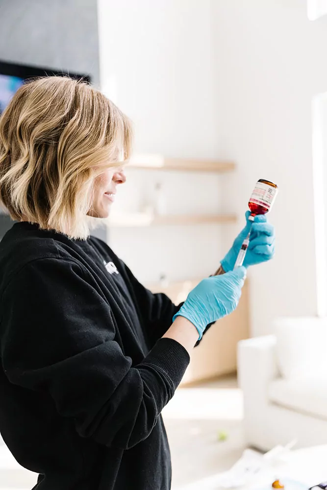 Nurse preparing IV therapy for fibromyalgia by drawing up vitamins out of a vial