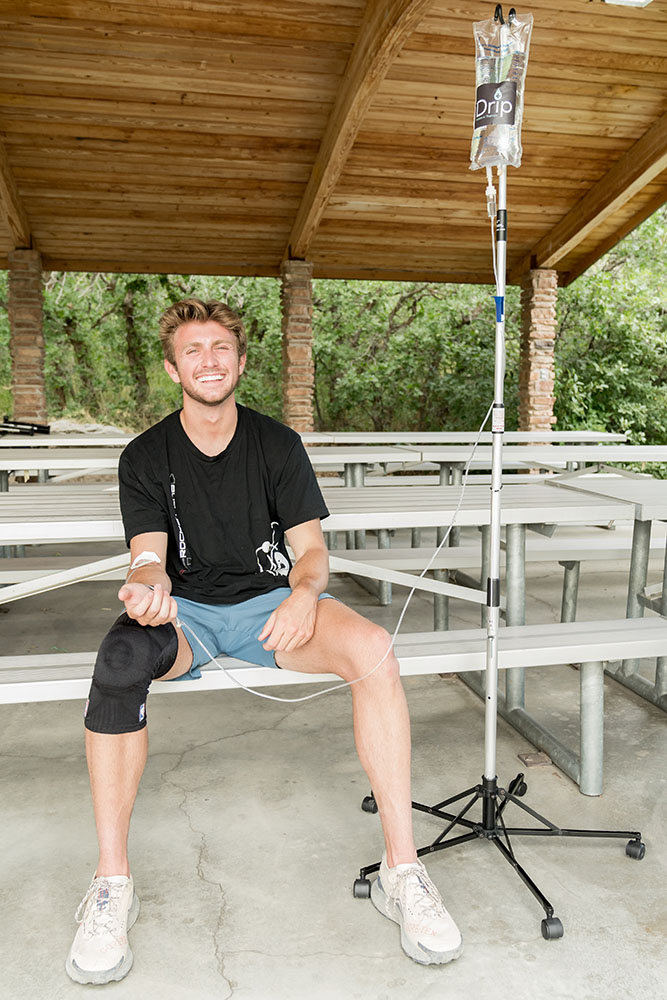 IV Therapy for Altitude Sickness being given outdoors to a man on a pavilion bench with IV bag hanging beside him