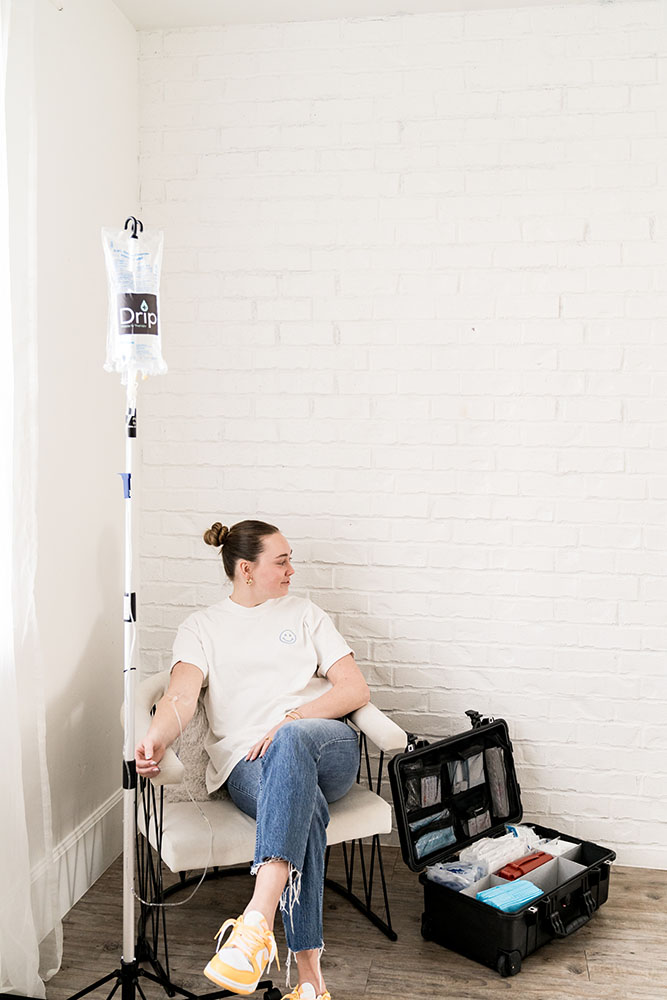 Woman getting at home iv therapy in woods cross ut. She is sitting in a chair with the IV bag hung on a stand