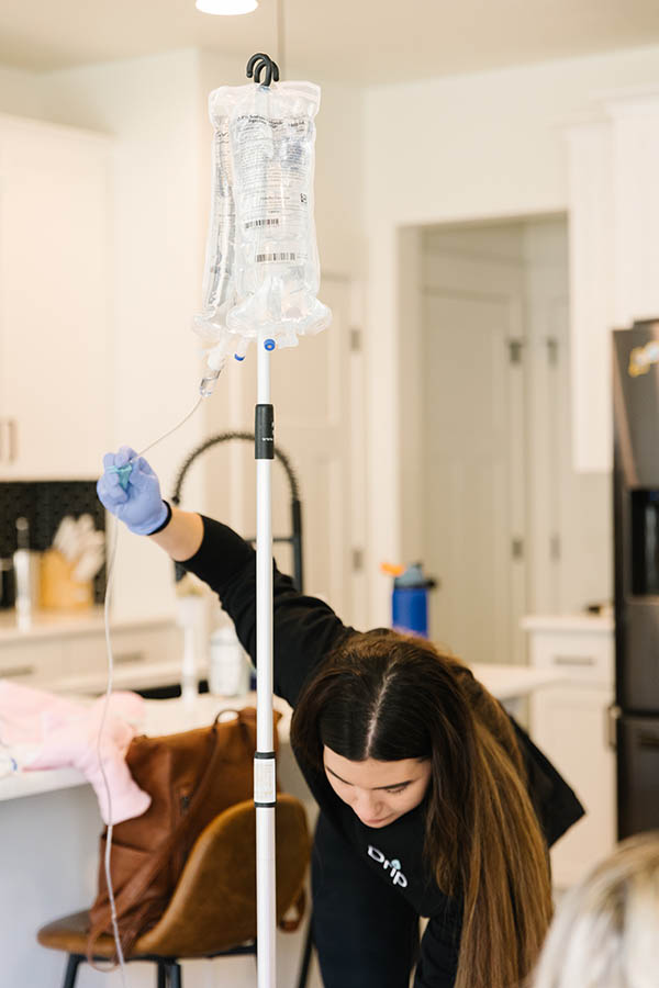 A nurse preparing a detox IV in a patient's living room