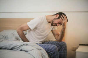 Man struggling because he didn't use vitamins to prevent hangover
