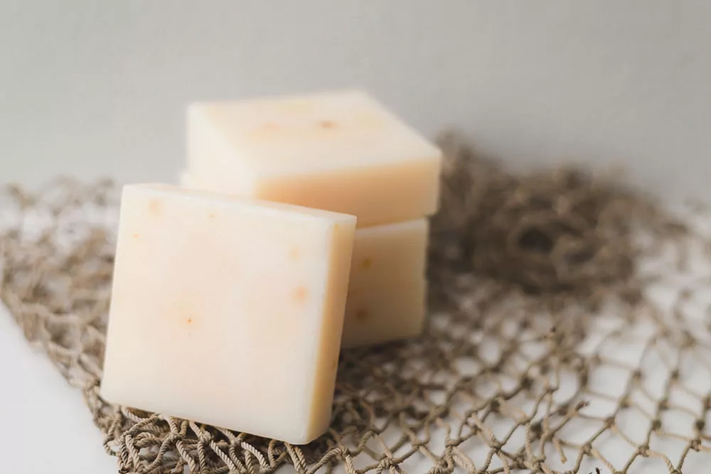 cheese is one of the foods high in vitamin d3. This image shows 4 thick slices of cheese on a thin brown rope net.